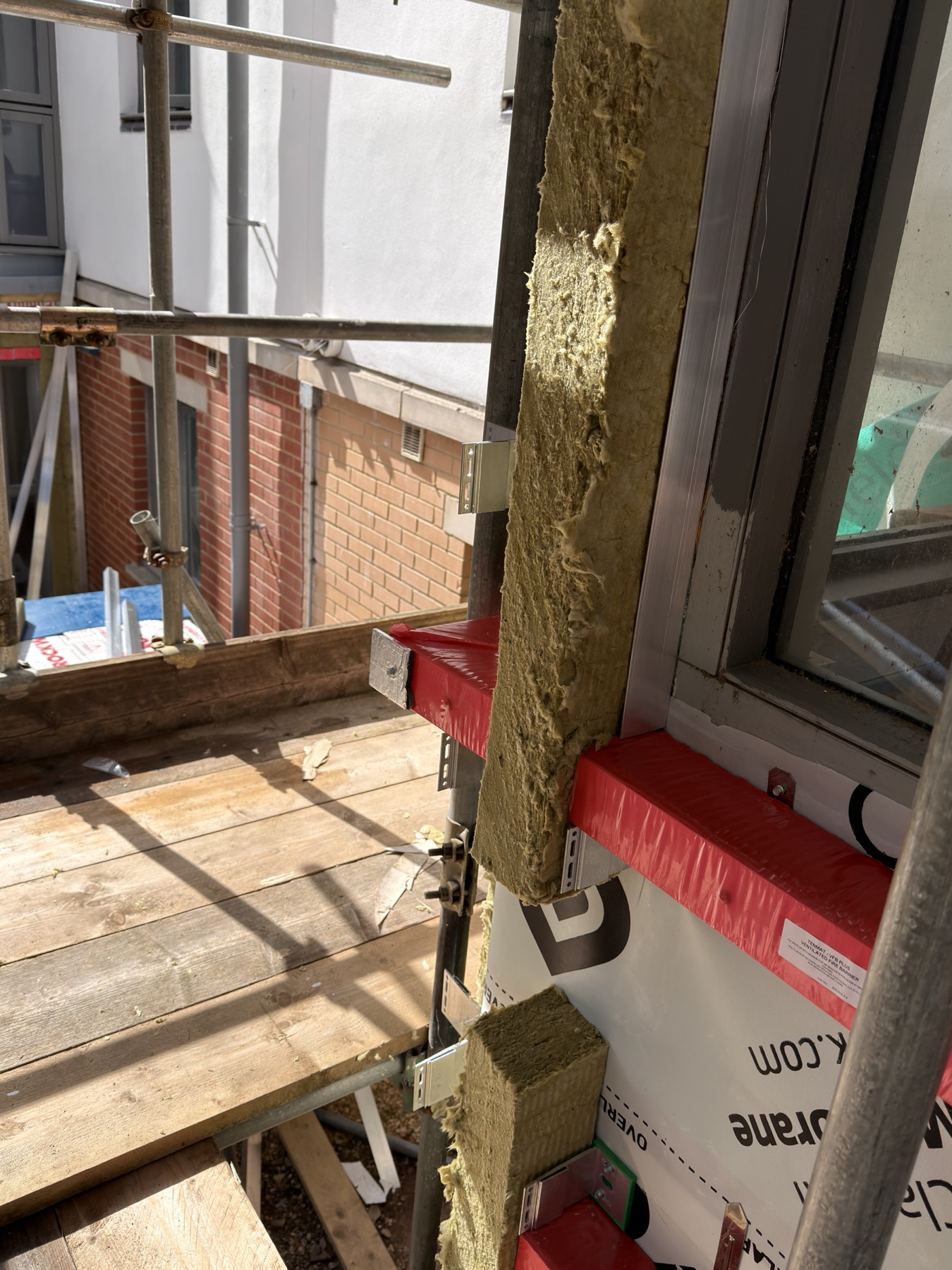 Fire barrier and cavity barrier interface detail before facade panel installation.