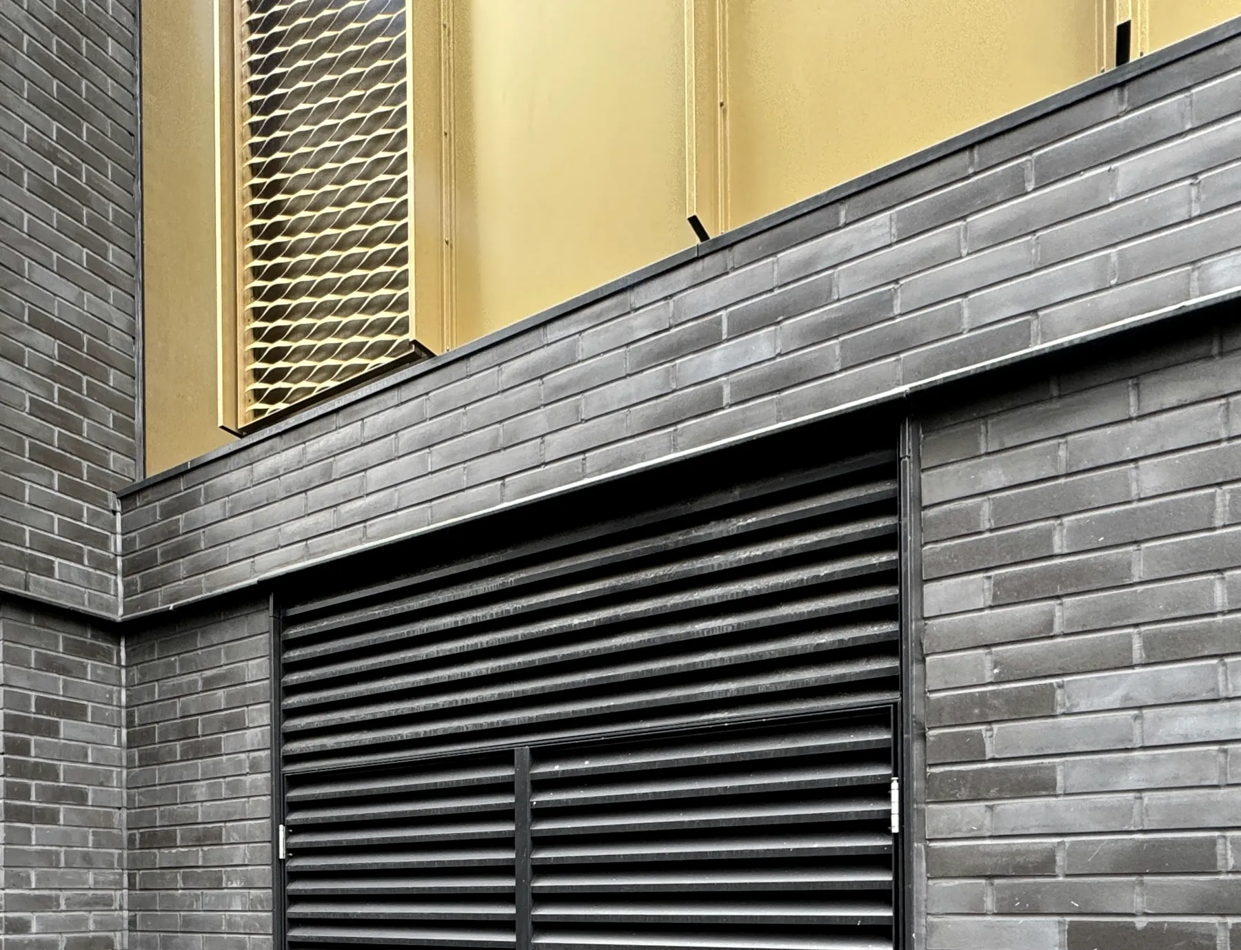 Cardiff brick slip facade system with louvres and interface detailing.