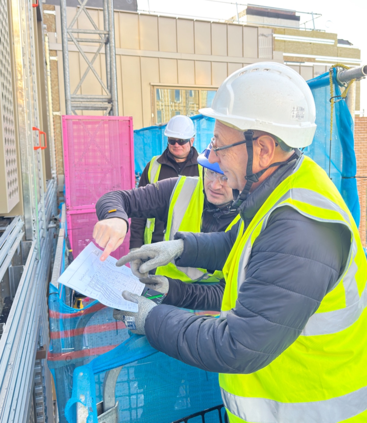 Facade installers checking approved drawings before installation